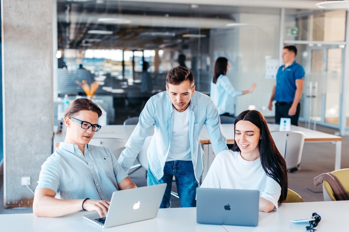 Professionals collaborating around a laptop while using AI meeting tools